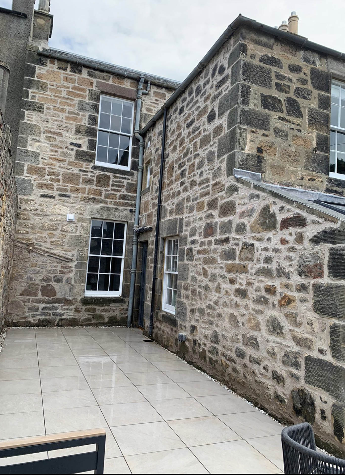 Rear elevation of a stone house with sash windows after repointing
